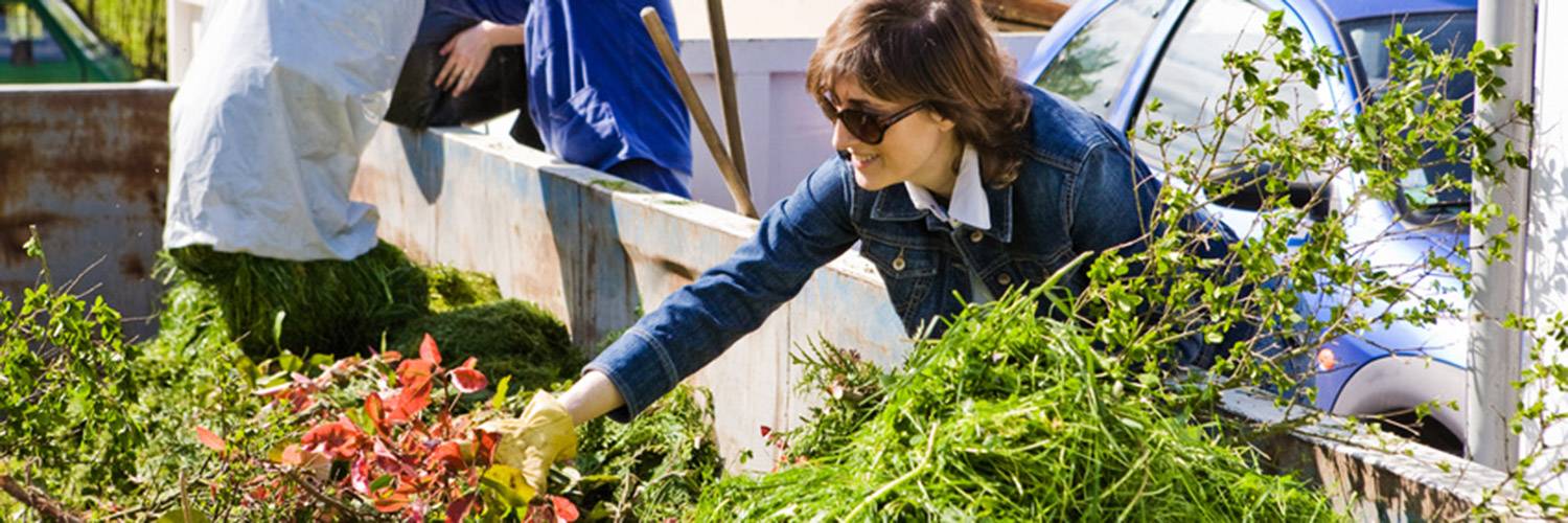 femme jettant des déchets verts dans une déchèterie